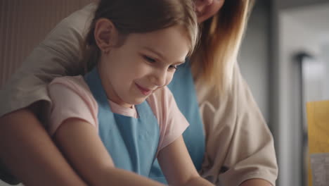 Una-Niña-Feliz-En-Edad-Preescolar-Y-Su-Madre-Están-Amasando-Masa-Juntas-Cocinando-En-La-Cocina-De-Casa